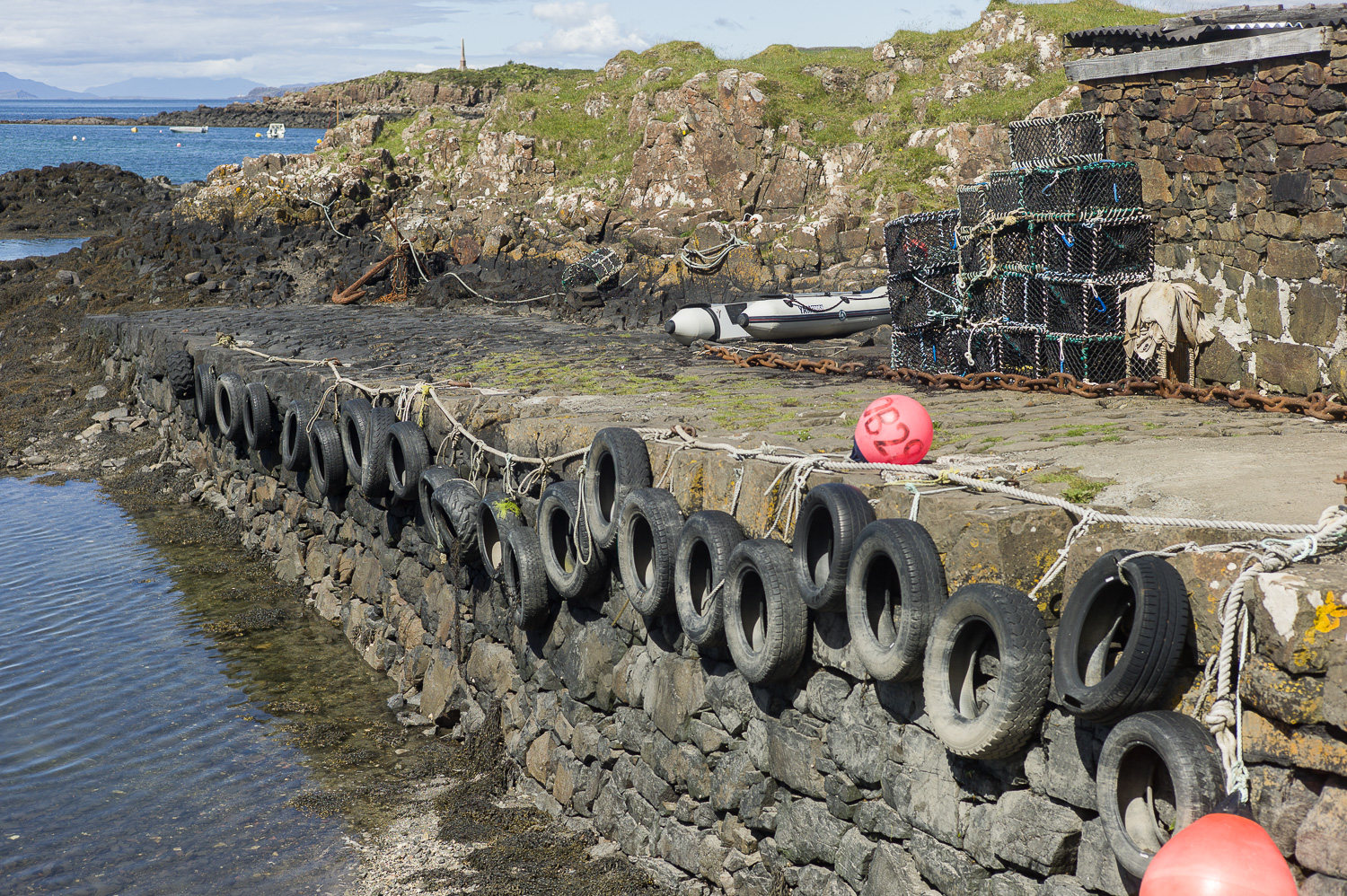 Oude autobanden als stootrand om de schepen te beschermen, kreeften kooien op de kade.